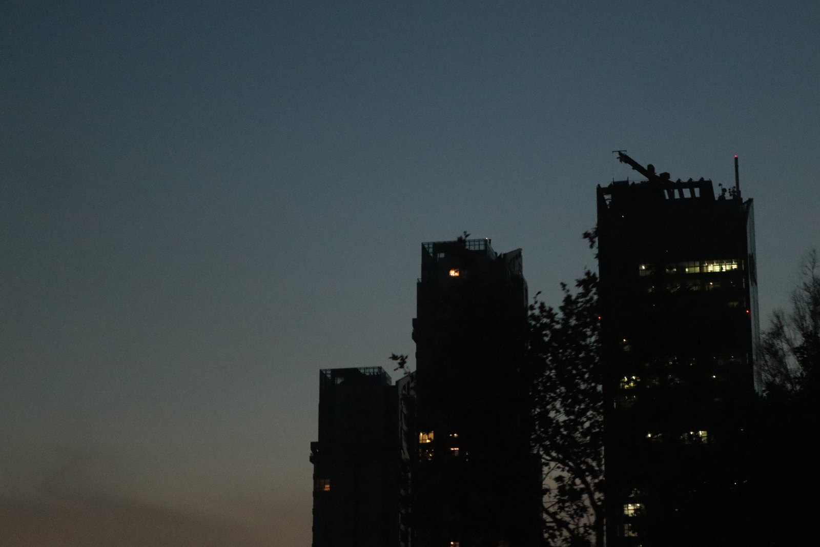 Tower silhouettes at dusk with a few lit windows